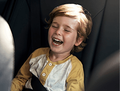 Little boy laughing in car