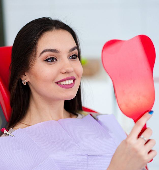 Woman looking at her smile in mirror