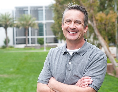 man smiling while standing outside 