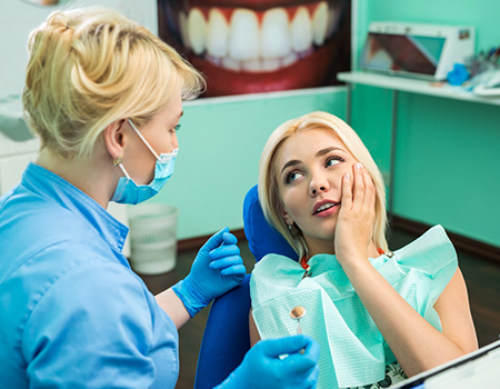 A young woman talking to her emergency dentist in Willow Grove