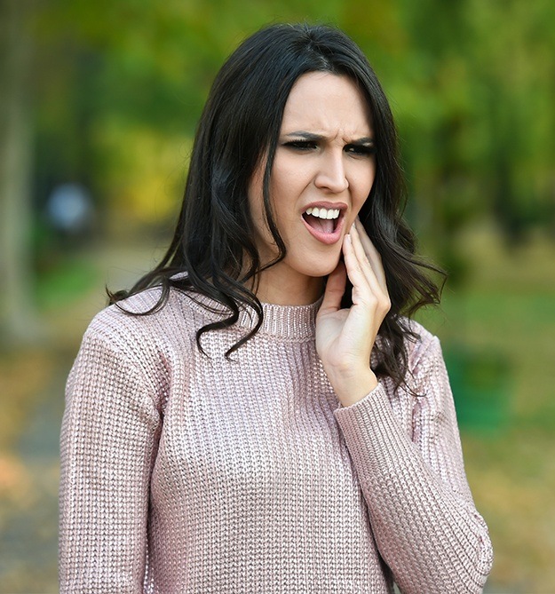 Woman in pain holding cheek