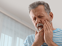 Man in pain holding jaw