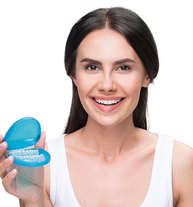 Woman holding Invisalign aligners