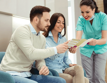 a front desk member explaining dental insurance to patients