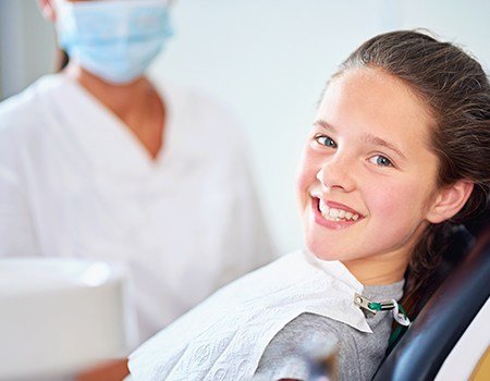 Smiling young girl in dental chair