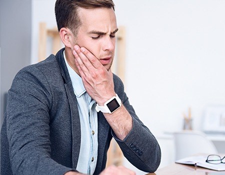 Man in pain holding jaw