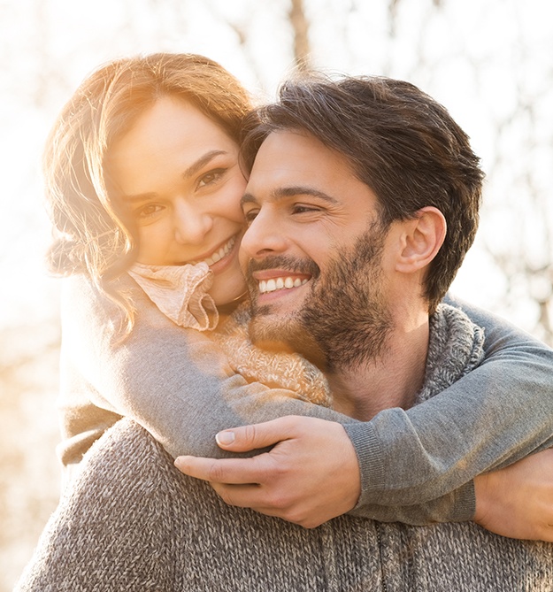 Smiling man and woman outdoors