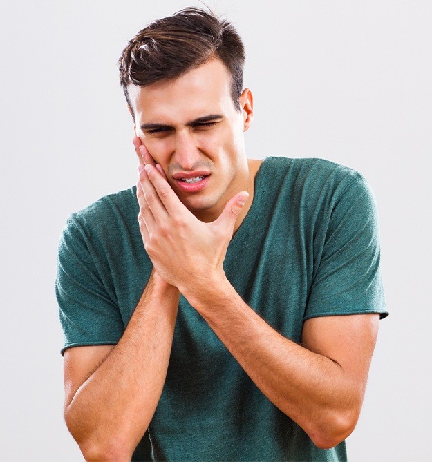 Man holding jaw in pain