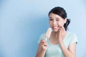 Wincing woman with popsicle 
