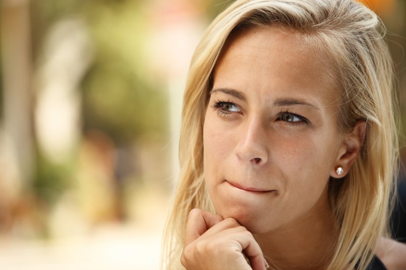 woman blonde hair pondering dental tips from her dentist