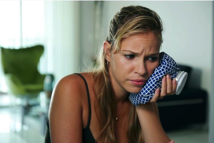 Woman with tooth pain needing to see an emergency dentist