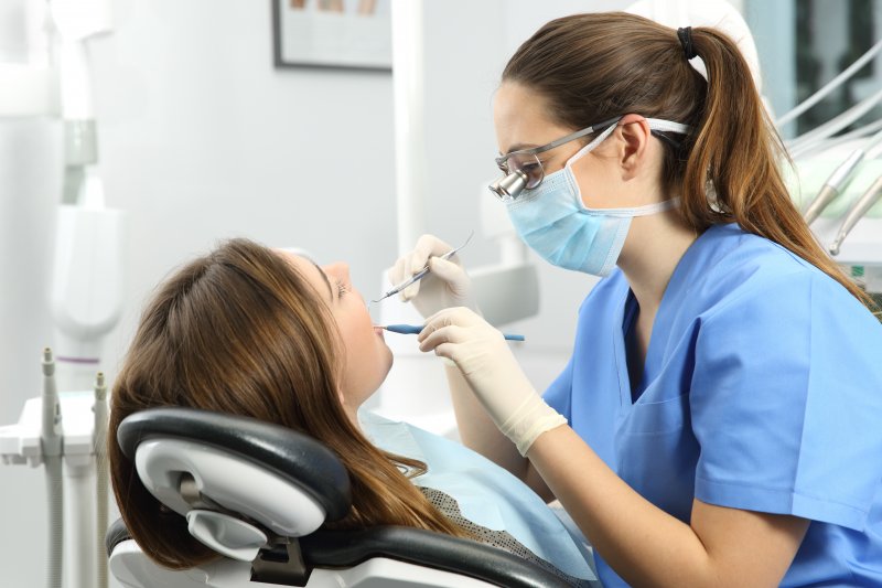 Dental hygienist examining patient's teeth