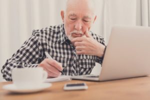 mature man writing on a notepad