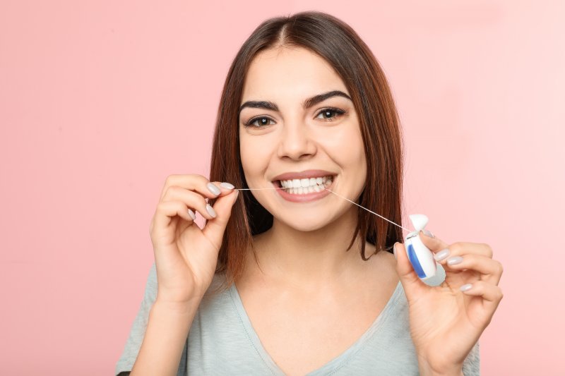 woman flossing with Invisalign in Willow Grove 