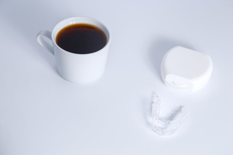 Invisalign aligners next to coffee mug