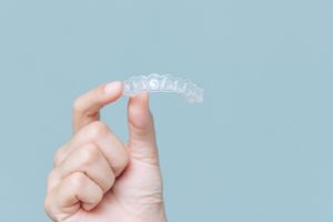 Closeup of a person holding an Invisalign aligner in Willow Grove