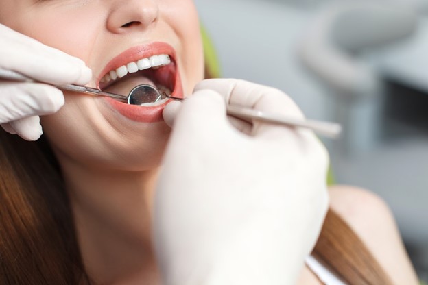 dentist performing oral cancer screening on patient