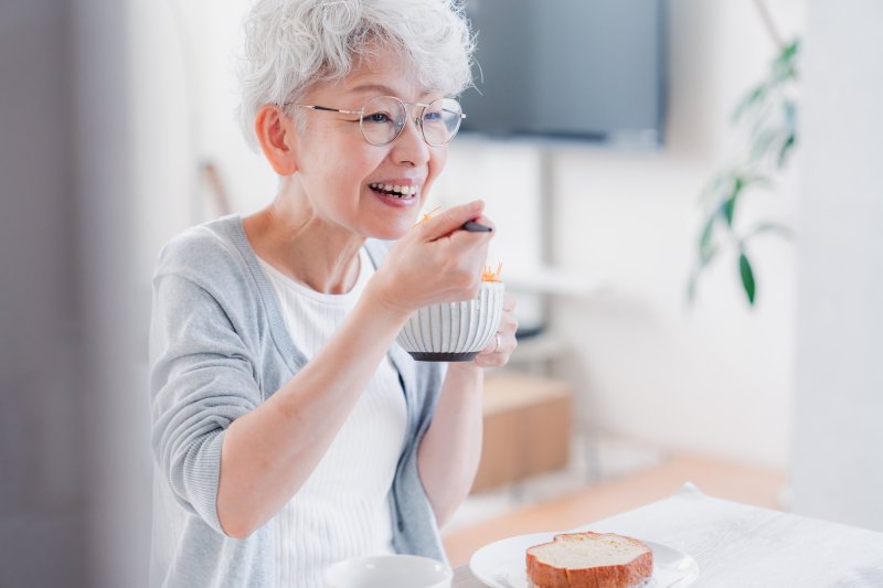 a woman with dentures enjoying a meal 