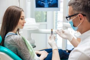 Dentist showing patient implant.